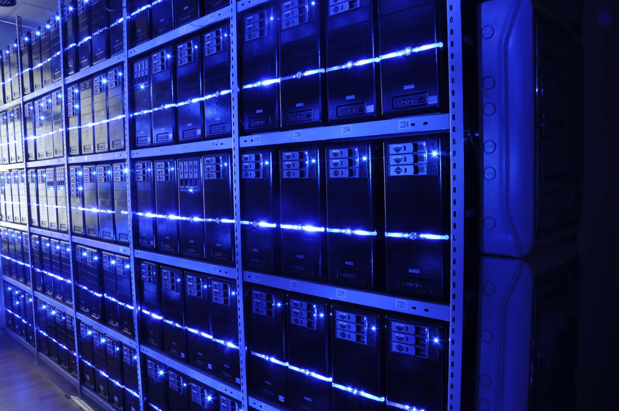 Rows of server racks and network cabling in a data center aisle